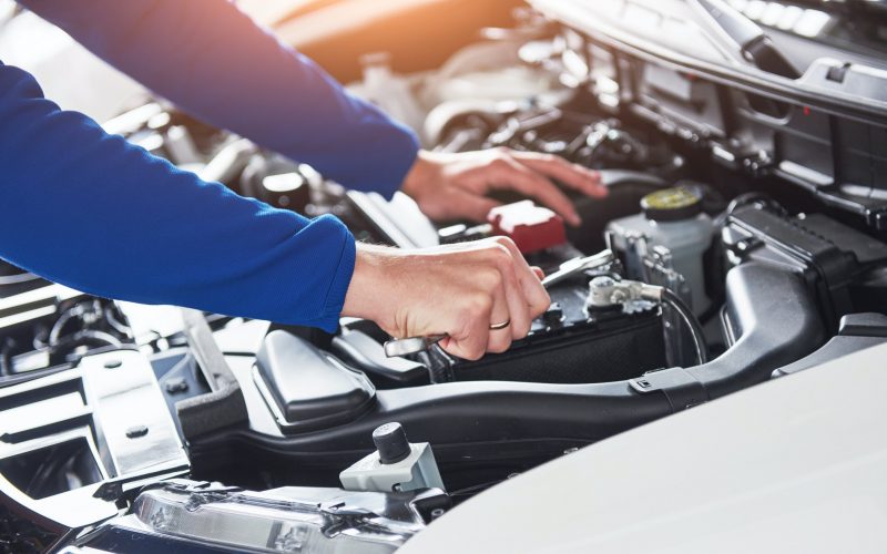 Hands of car mechanic with wrench in garage